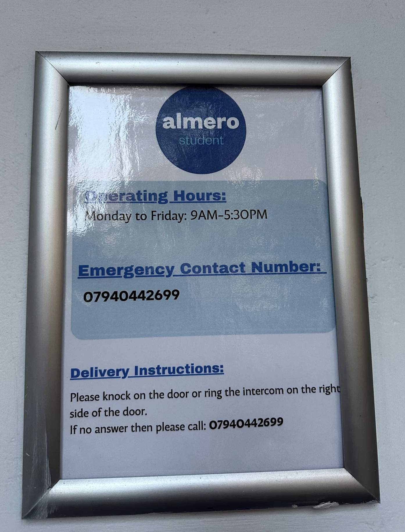 Almero Student operating hours and emergency contact sign displayed at the building